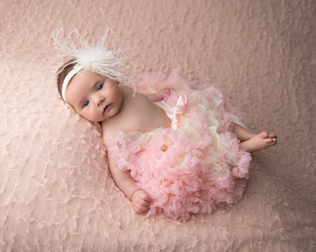 Six-week-old baby girl in a soft pink newborn photography setup at Image Is Everything Studios in South Jersey.