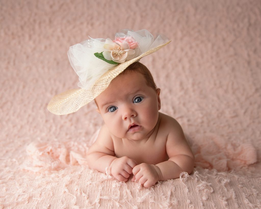 Older newborn photography in South Jersey featuring a wide-awake six-week-old baby girl wrapped in soft pink and neutral tones.
Copy alt text